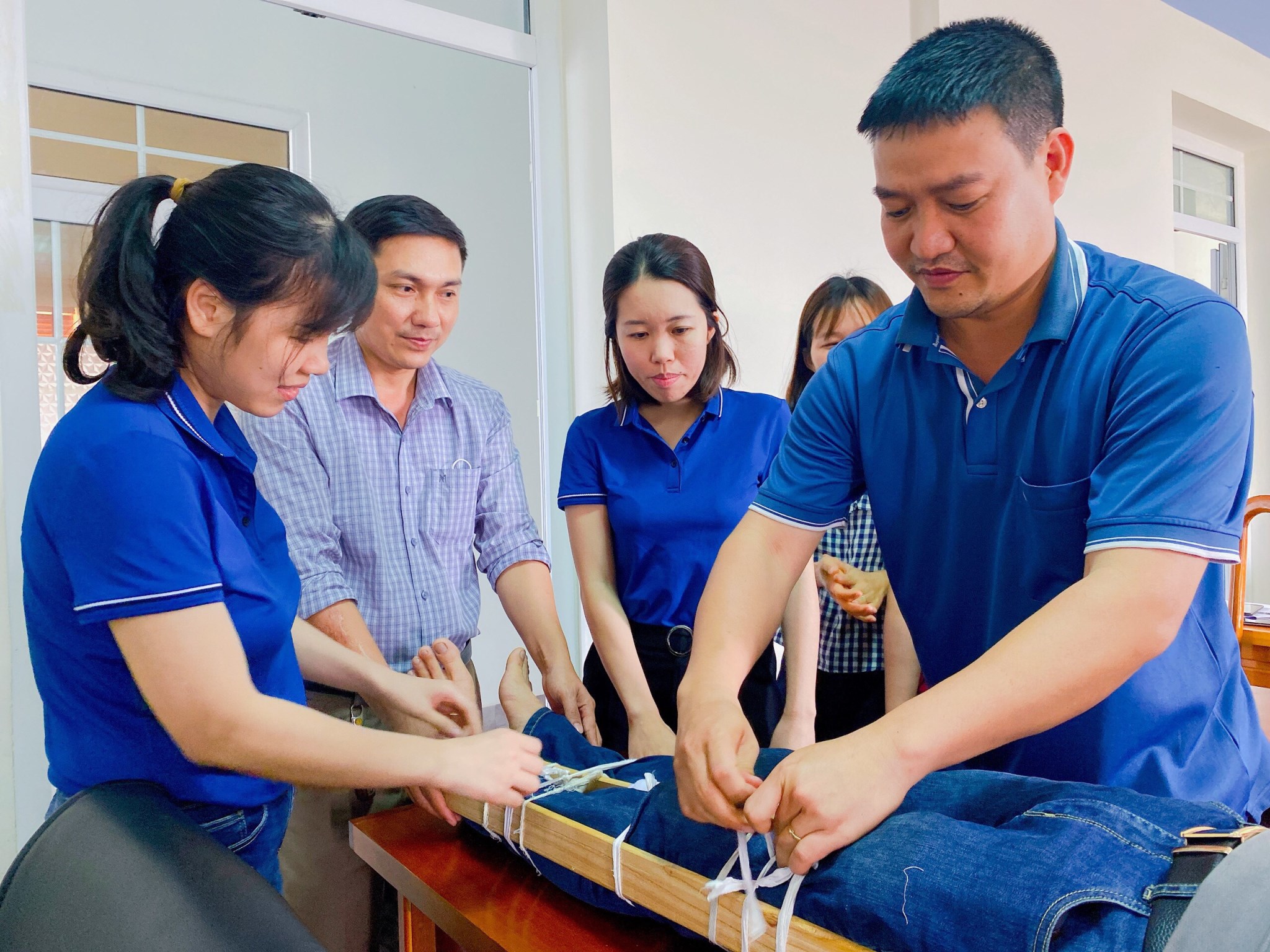 Các học viên thực hành phương pháp sơ cấp cứu nạn nhân cố định xương gãy bằng nẹp cứngjpg