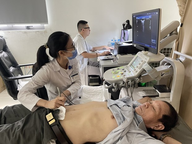 Nhân viên y tế thực hiện siêu âm ổ bụng cho một bệnh nhânjpg