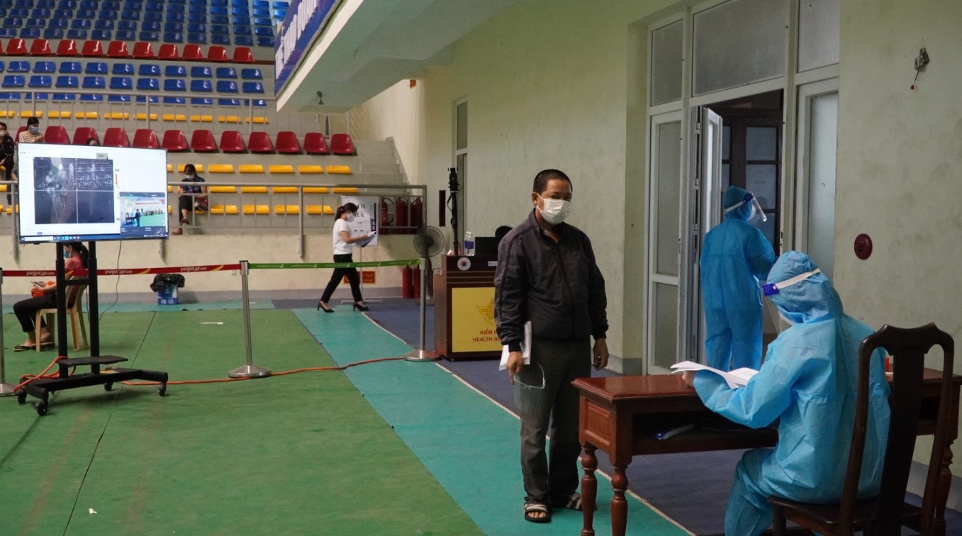 Đo thân nhiệt cho các đối tượng đến tiêm bằng máy đo thân nhiệt tự độngjpg